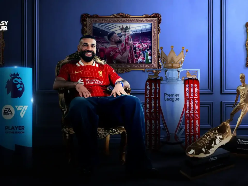 محمد صلاح يجلس على عرش كروي مرتدياً قميص ليفربول، محاطًا بجوائز الدوري الإنجليزي الممتاز مثل الكأس، الحذاء الذهبي، مع صور له في الخلفية توثق لحظات تتويج وانتصارات.