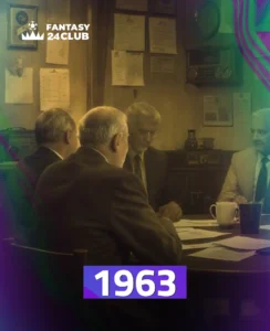 مجموعة من الرجال يجلسون حول طاولة، في ما يبدو أنه اجتماع أو نقاش، مع وجود أوراق على الطاولة وخلفهم حائط عليه وثائق. الرقم "1963" يظهر بوضوح
